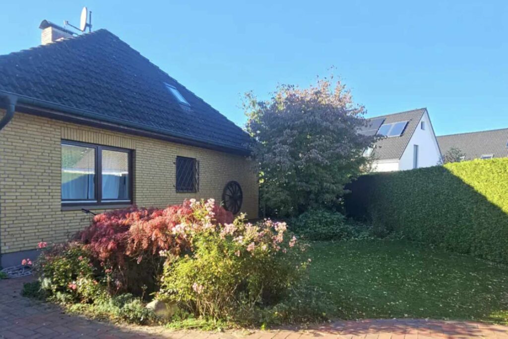 Gartenansicht mit gepflegten Büschen und Weg zum Haus